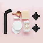 Clark Cross matte black wall top assemblies with cross handles, shown with bathroom accessories on a pink background
