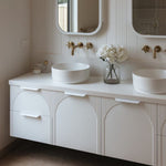 ADP Archie wall hung vanity with Caesarstone top, white arched front and twin above-counter basins in a bathroom setting