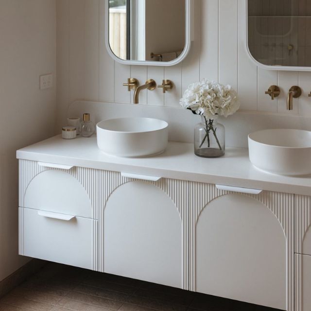 ADP Archie wall hung vanity with Caesarstone top, white arched front and twin above-counter basins in a bathroom setting