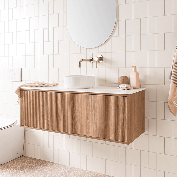 ADP Clifton wall-hung ensuite vanity with white top, Prime Oak woodgrain front and round basin in a tiled bathroom
