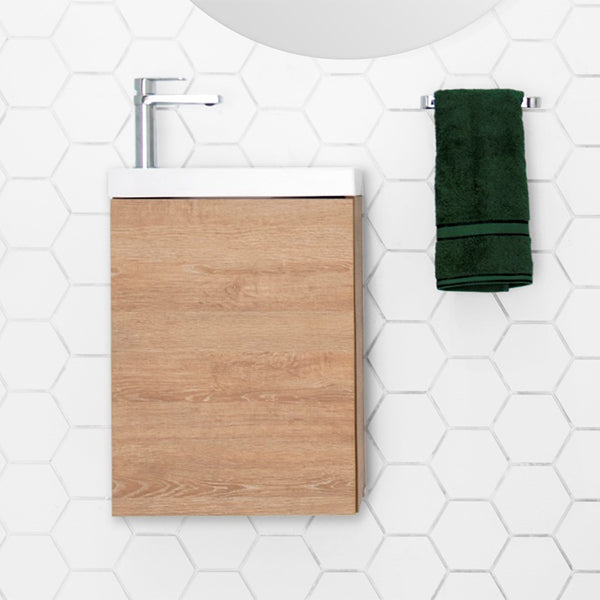 ADP Petite wall-hung vanity with woodgrain front and white top, shown in bathroom setting with hexagonal wall tiles and chrome mixer tap