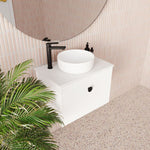 Marquis Anna wall hung ensuite vanity in white with round above-counter basin and black tapware, styled in a bathroom setting