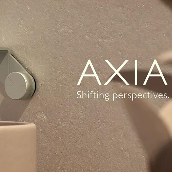 Phoenix Axia wall mixer in brushed nickel, shown partially mounted on a bathroom wall with AXIA branding.