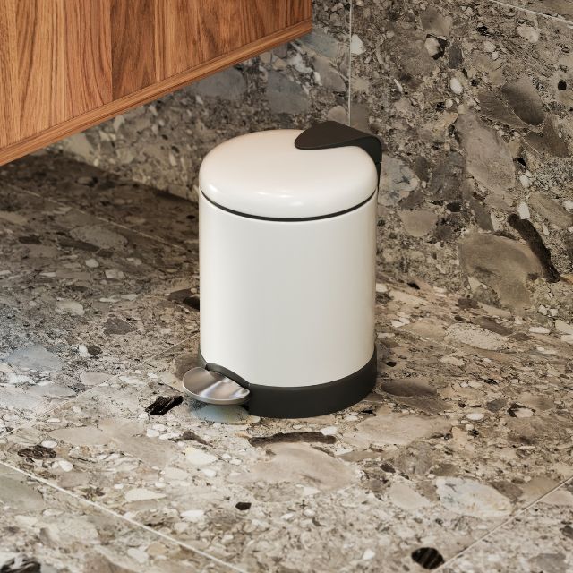 Bao Bath round pedal bathroom bin in matt white with black base and lid, shown freestanding on a stone floor￼