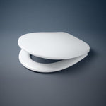 Caroma Profile white toilet seat with soft close hinges, closed on dark background