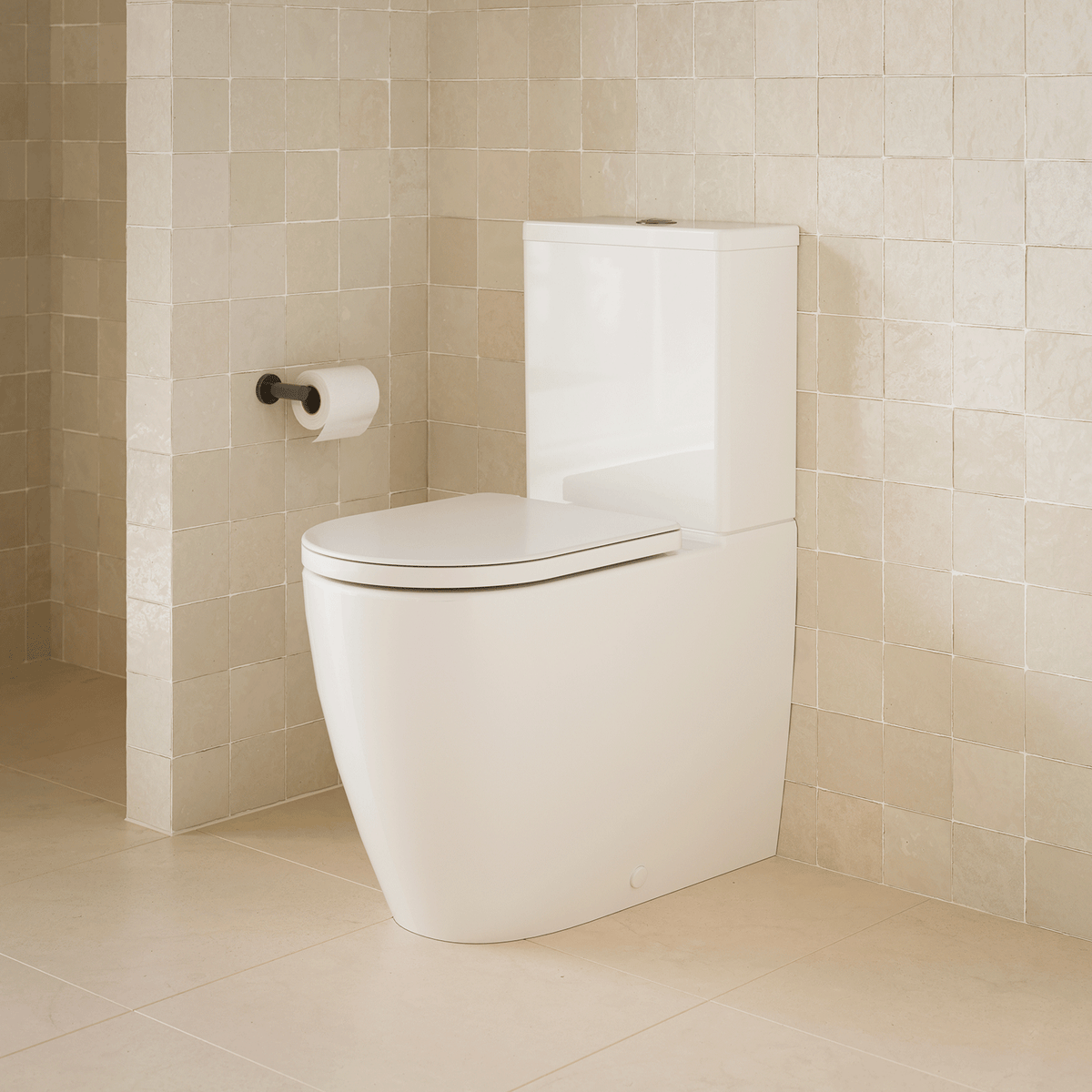 Caroma Urbane II Luxe wall-faced toilet suite in white, shown in a beige tiled bathroom with concealed cistern and soft-close seat