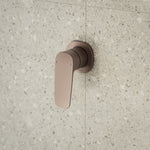 Caroma Contura II wall-mounted bath/shower mixer in brushed bronze, single lever on stone-look bathroom tiles