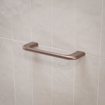 Caroma Contura II hand towel rail in brushed bronze on tiled bathroom wall