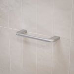 Caroma Contura II brushed nickel hand towel rail mounted on light tiled bathroom wall