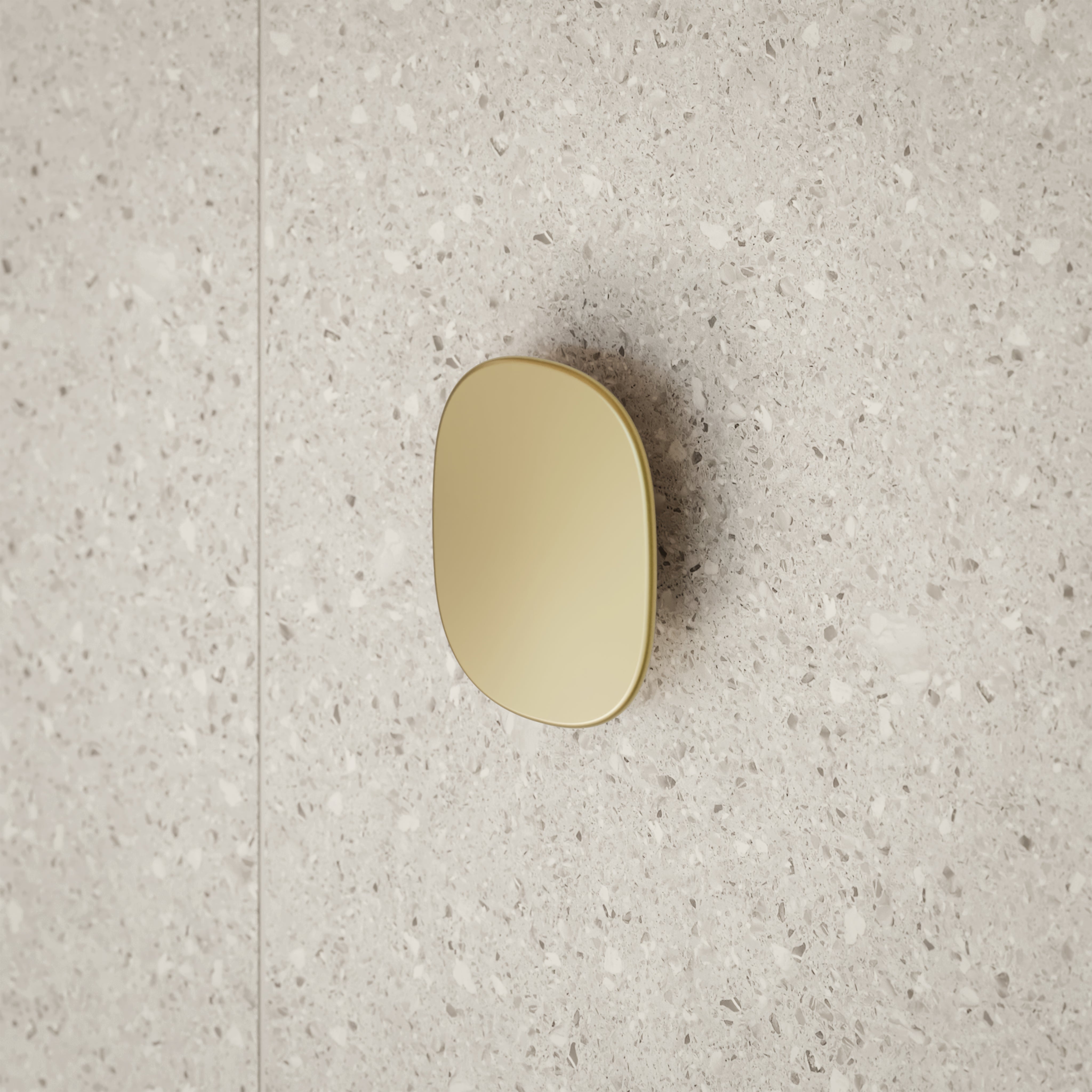 Caroma Contura II large robe hook in brushed brass on a speckled stone bathroom wall