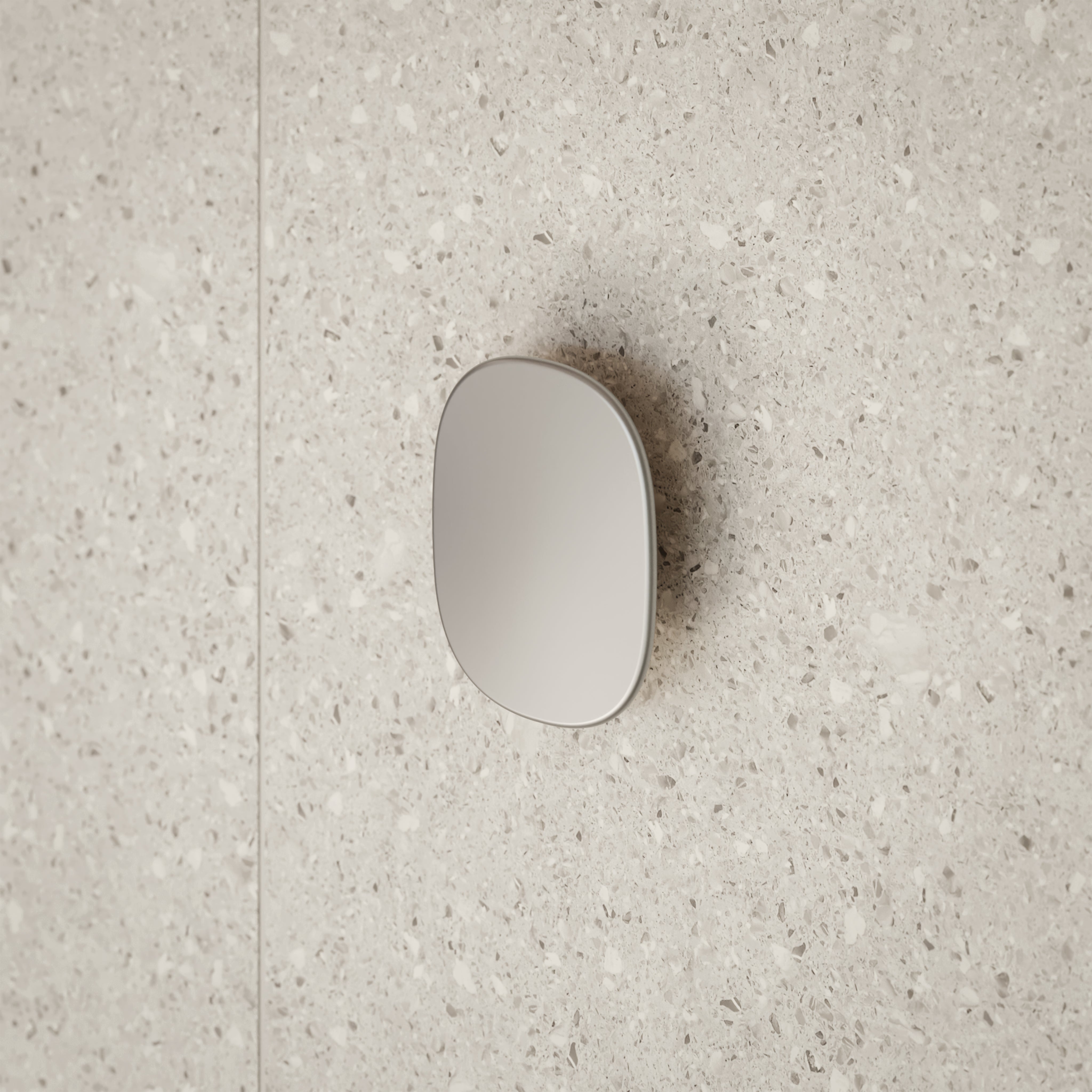Caroma Contura II large robe hook in brushed nickel, close-up on speckled stone bathroom wall