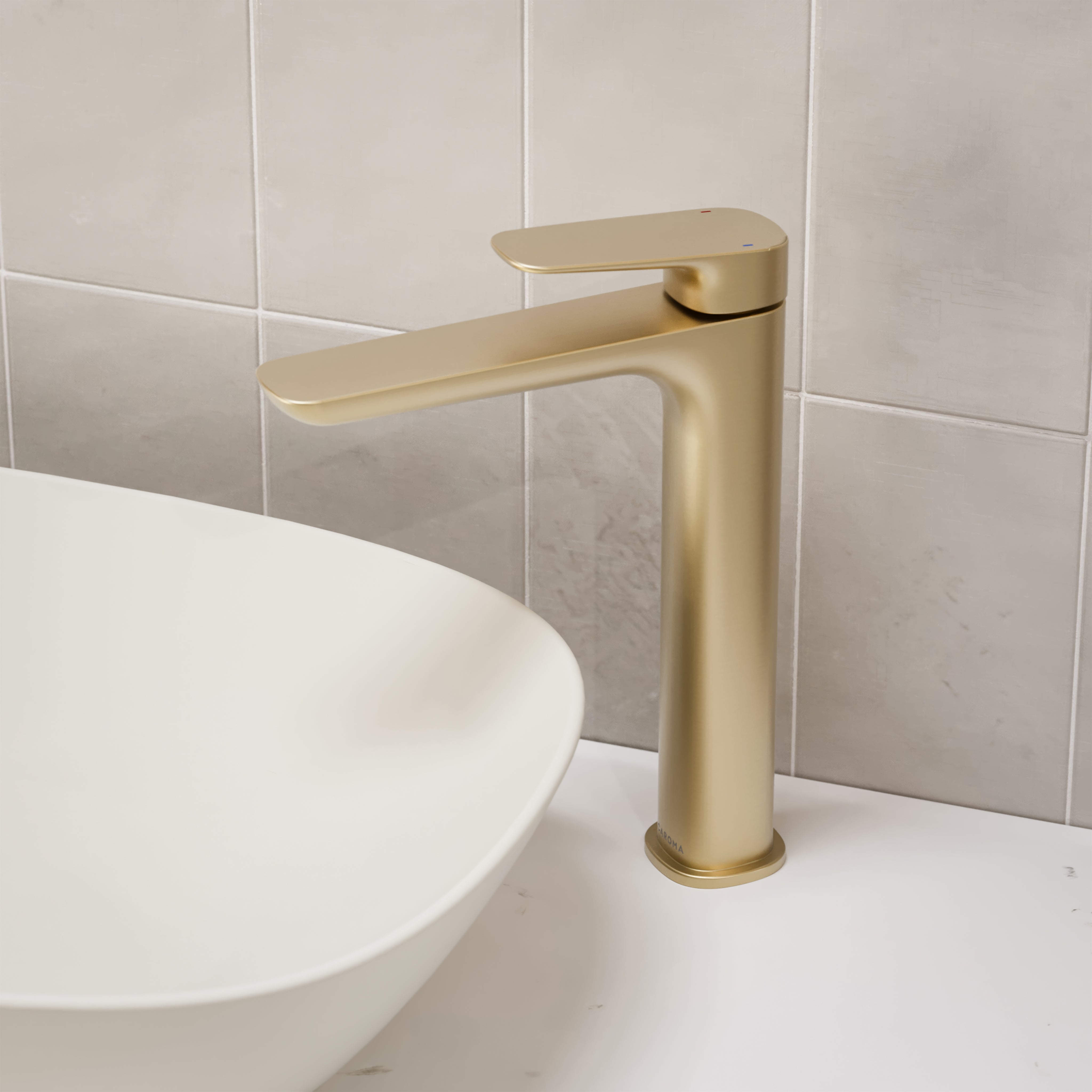 Caroma Contura II tower basin mixer in brushed brass, shown mounted beside an above-counter basin on a benchtop.