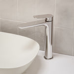 Caroma Contura II tower basin mixer in chrome, shown hob mounted beside a white above-counter basin.
