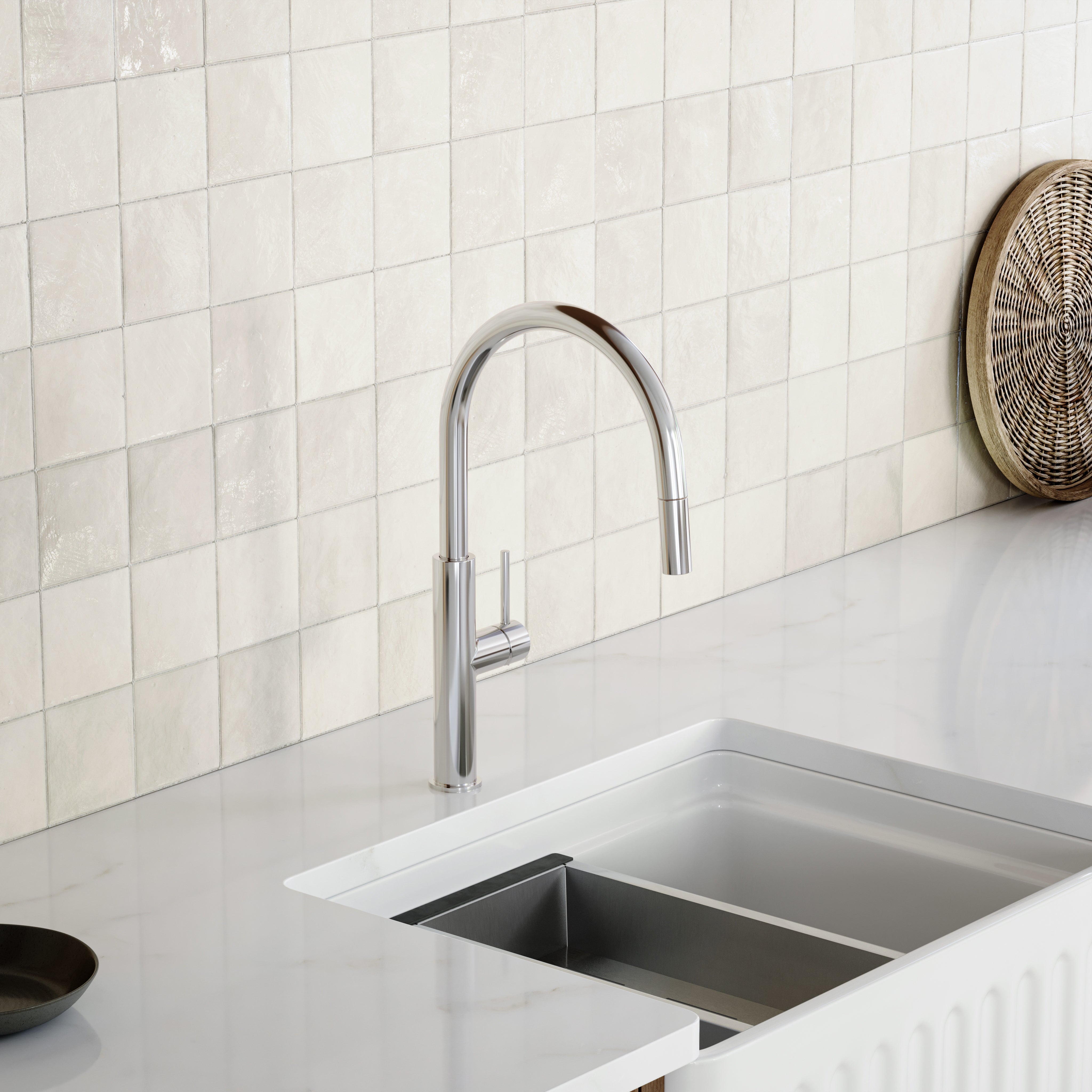 Caroma Liano II chrome pull out sink mixer on a white kitchen benchtop with square tiled splashback