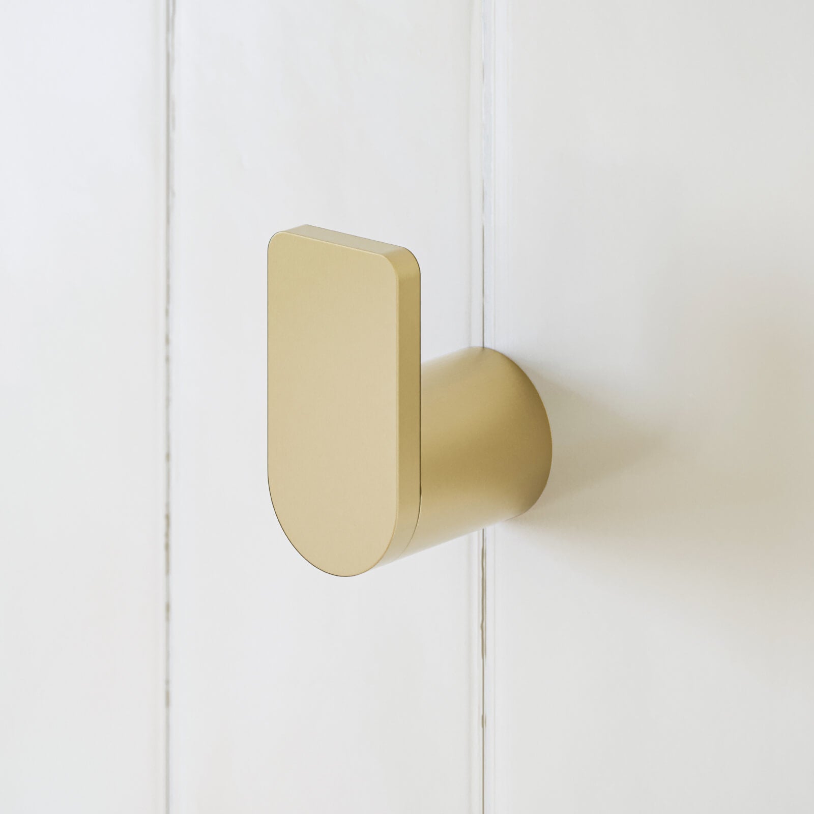 Caroma Urbane II brushed brass robe hook on white wall, shown in close-up side view