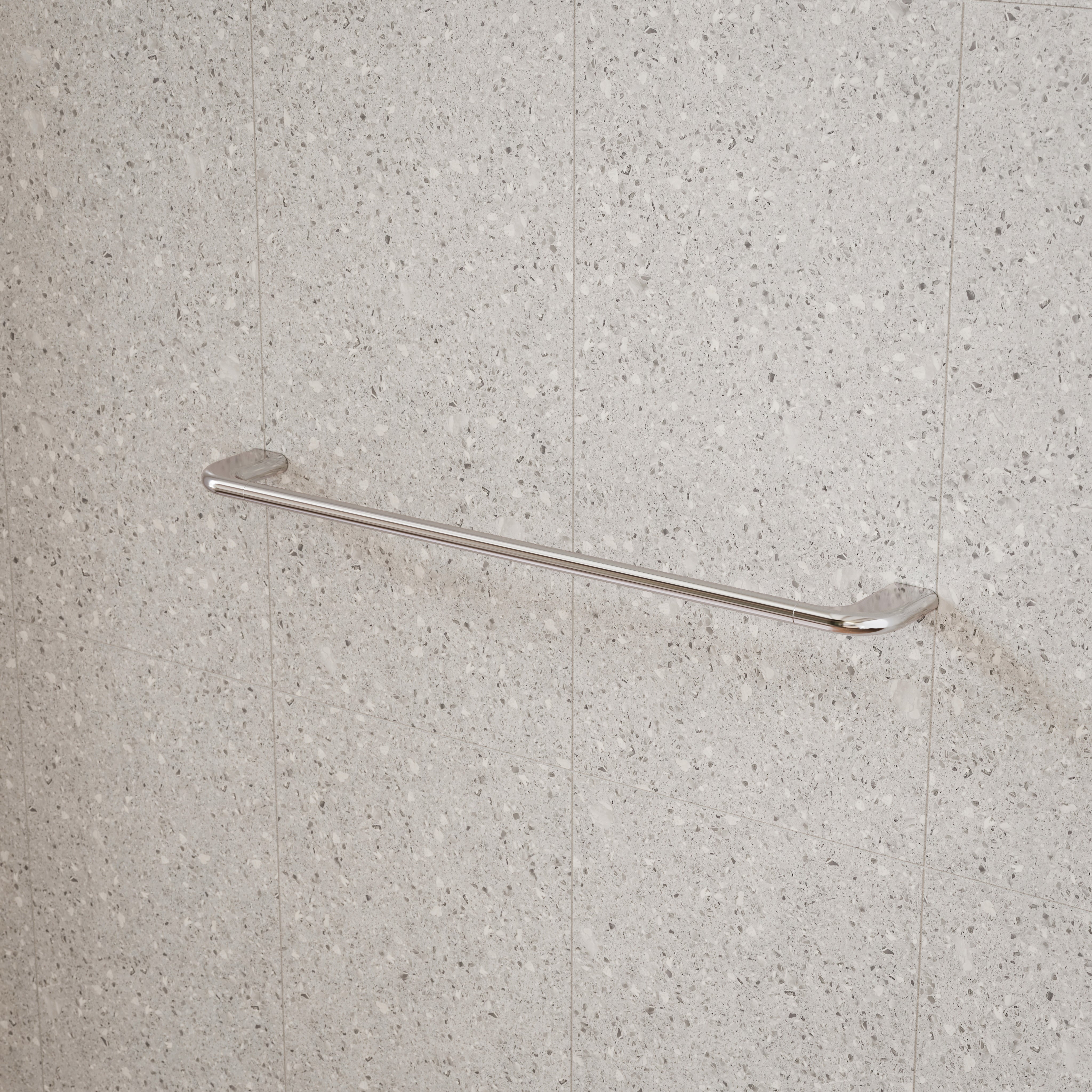 Caroma Contura II chrome single towel rail mounted on speckled tile wall