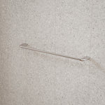 Caroma Contura II chrome single towel rail mounted on speckled tile wall
