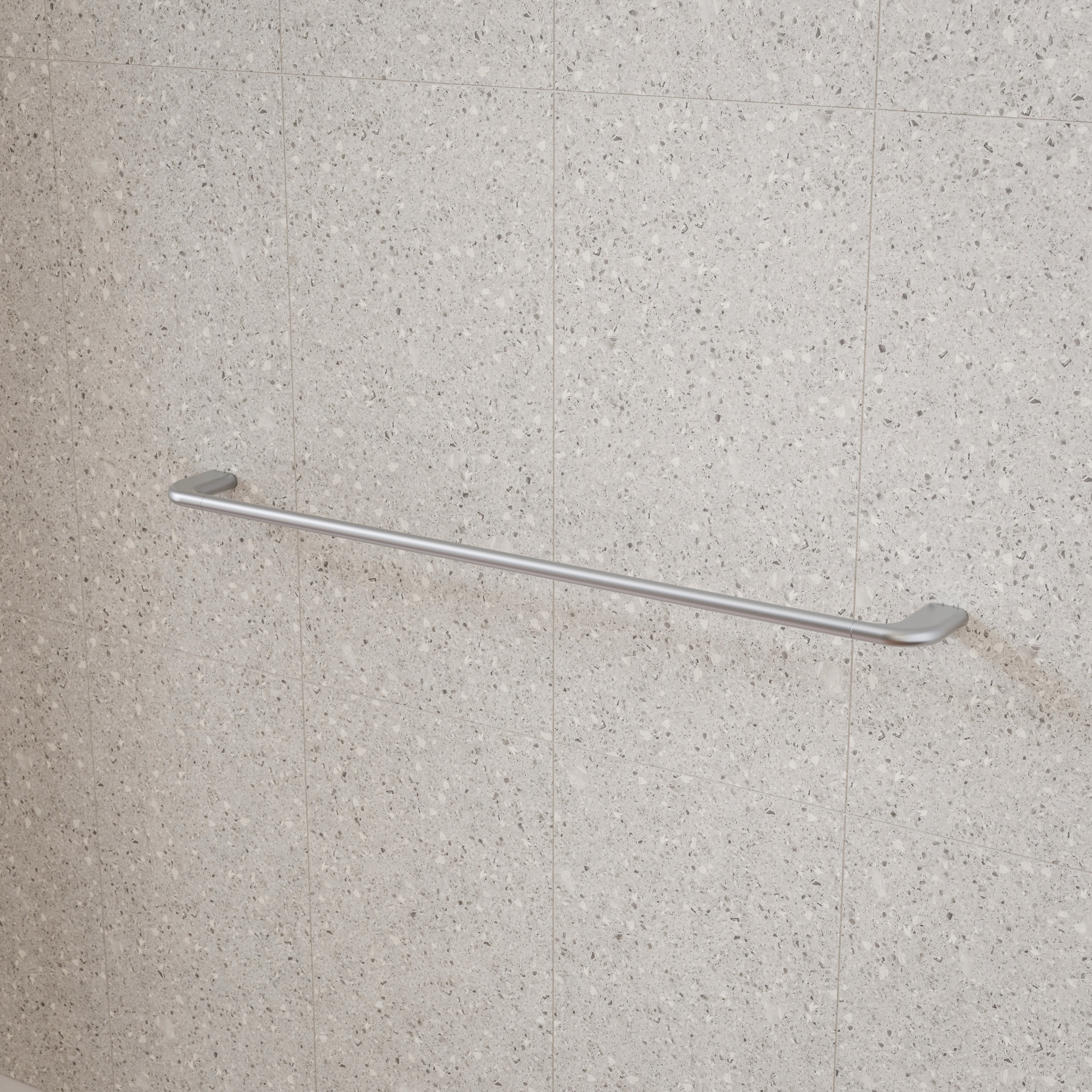 Caroma Contura II brushed nickel single towel rail mounted on a tiled bathroom wall