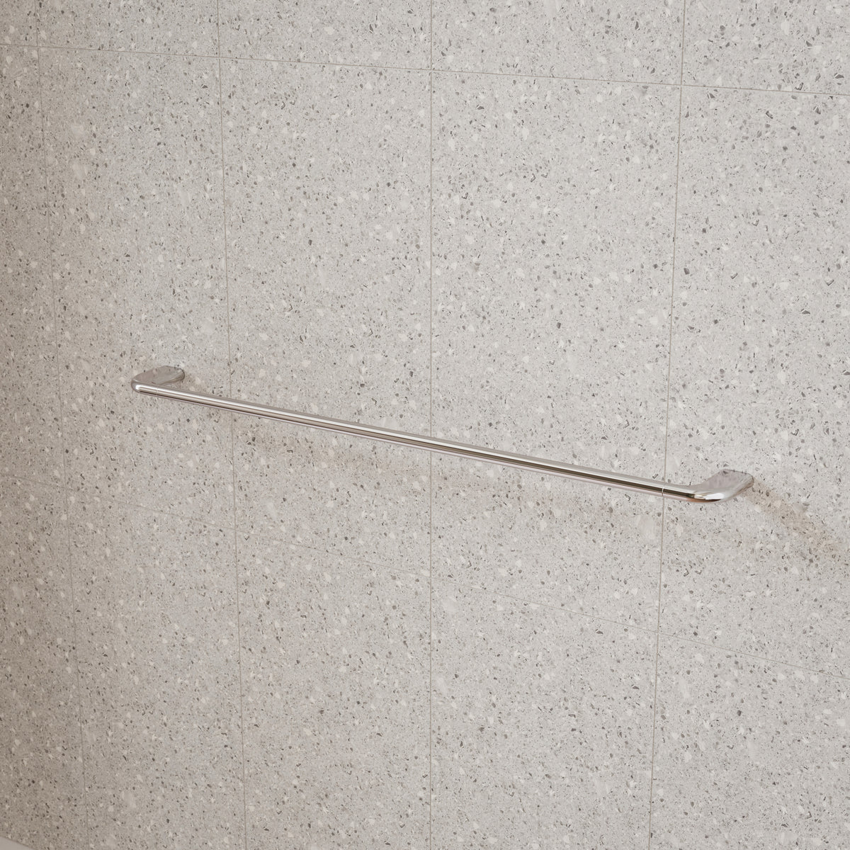Caroma Contura II single towel rail in chrome, mounted on a light speckled bathroom tile wall