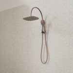 Caroma Contura II compact twin shower in brushed bronze, with round overhead rose and hand shower on rail