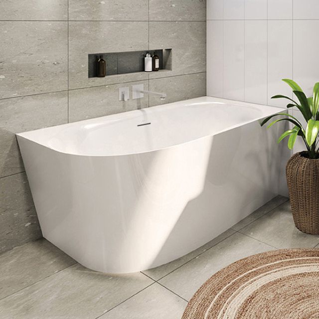 Decina Natalia white back-to-wall corner bath in a tiled bathroom, with oval interior and integrated overflow visible