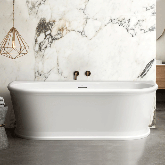 Decina Oxford white gloss back-to-wall freestanding bath, oval Hamptons style, shown against a marble feature wall.