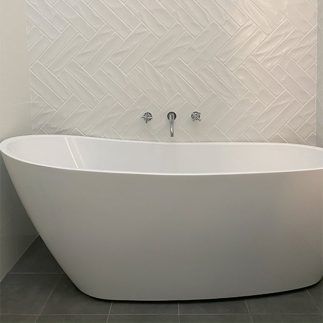 Clark round chrome swivel bath outlet above a freestanding white bath in a modern bathroom