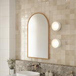 Ingrain timber framed arch mirror with natural ash finish, wall hung above vanity in a tiled bathroom scene
