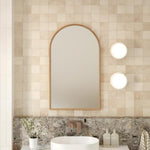 Ingrain timber framed arch mirror with natural woodgrain finish, mounted above a bathroom vanity in portrait view