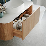Ingrain curved fluted wall hung vanity in woodgrain with white top, open drawer and rounded basin in bathroom setting
