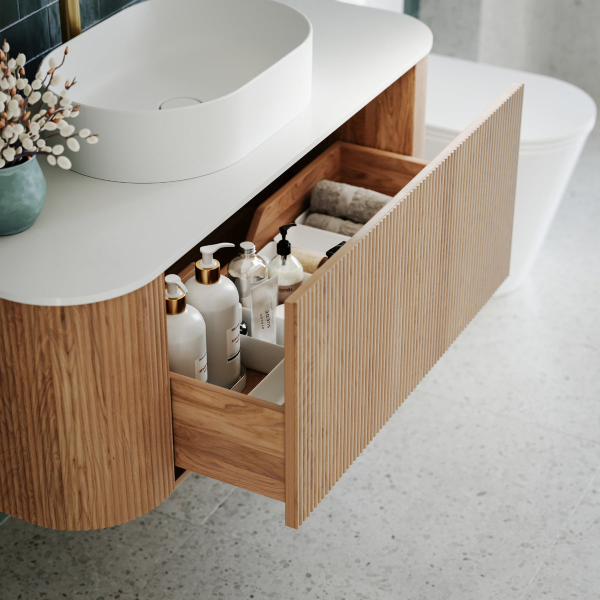 Ingrain curved fluted wall hung vanity in woodgrain with white top, open drawer and rounded basin in bathroom setting