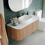Ingrain curved fluted wall hung vanity with white top, oval basin and woodgrain drawer fronts in bathroom setting