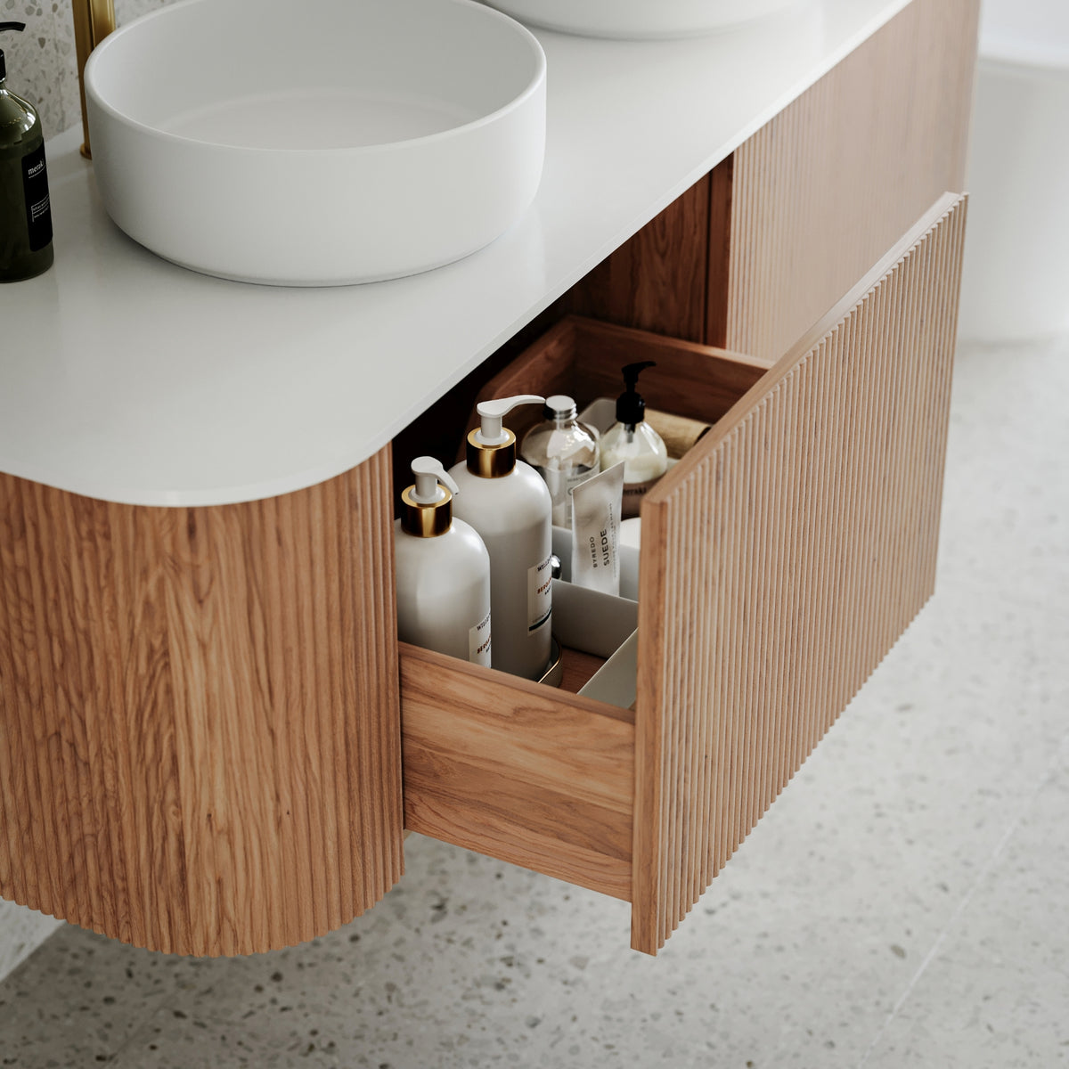Ingrain curved fluted wall hung vanity in woodgrain finish with white top and open drawer in bathroom setting