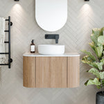 Ingrain curved fluted wall hung vanity with white top and oval basin in light woodgrain bathroom setting