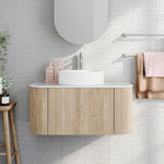 Ingrain curved fluted wall hung vanity in woodgrain with white top and round basin in a bathroom setting