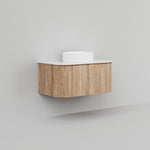 Ingrain Curved Fluted wall hung vanity, woodgrain finish with white top, shown floating in a minimalist bathroom setting