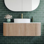 Ingrain curved fluted wall hung vanity in woodgrain with white top and basin, front view against green tiled wall