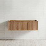 Ingrain Grooved wall-hung vanity in ash woodgrain with fluted drawer front, shown front on against a white tiled wall.