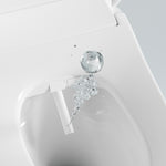 Lafeme Catania white bidet toilet seat detail, showing self-cleaning nozzle and water spray underneath the lid