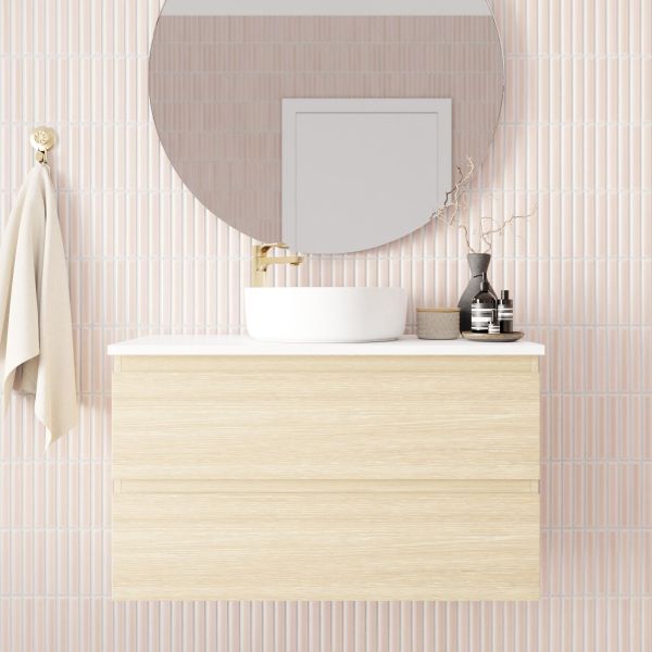 Marquis Marq wall hung vanity in light woodgrain with white top and centre basin, shown styled in bathroom setting