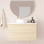 Marquis Marq wall hung vanity in light woodgrain with white top and centre basin, shown styled in bathroom setting