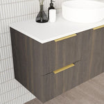 Marquis Arco wall hung vanity in dark woodgrain with white top and brushed brass handles, angled bathroom view