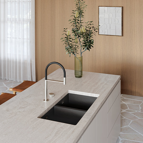 Phoenix 5000 Series matte black double bowl kitchen sink installed in a light stone benchtop, angled kitchen view