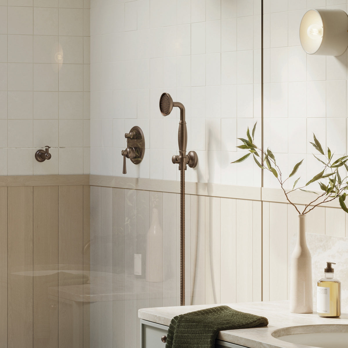 Phoenix Cromford hand shower in brushed bronze, mounted in a tiled bathroom shower setting