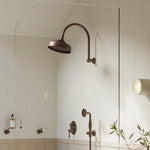 Phoenix Cromford 210mm shower rose in brushed bronze, wall-mounted in a tiled bathroom scene