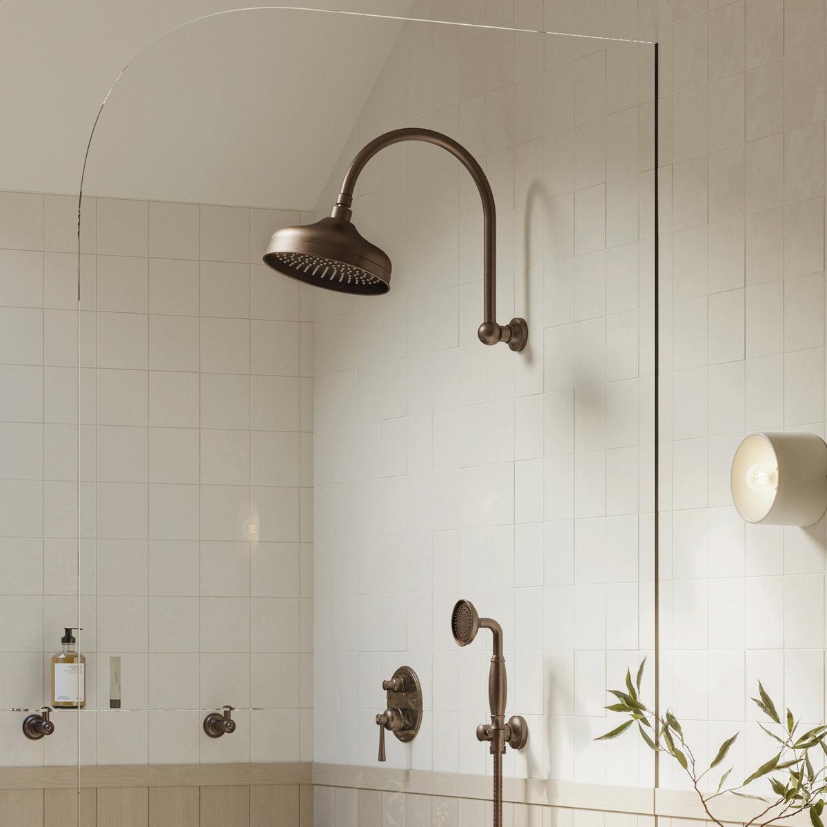 Phoenix Cromford 210mm shower rose in brushed bronze, wall-mounted in a tiled bathroom scene
