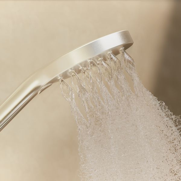 Phoenix Oxley brushed gold twin rail shower rose, angled close-up, spraying water against a beige background