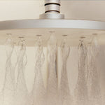 Phoenix LuxeXP Round Shower Rose 250mm in chrome, showing the wide soft spray from below in a bathroom setting