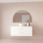 Marquis Riviera wall hung vanity in white with brushed brass pulls and round basin, styled against pink tiled wall
