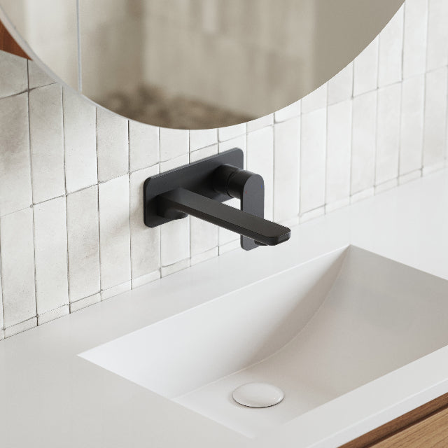 Caroma Luna wall-mounted basin/bath mixer in matte black above a white vanity basin, side view